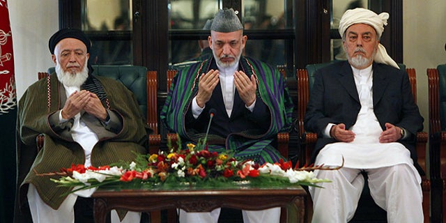 Oct. 7: Afghan President Hamid Karzai, center, prays with members of the Afghanistan peace council in Kabul.