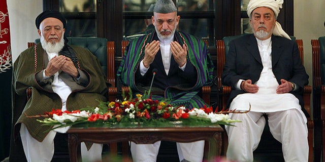 Oct. 7: Afghan President Hamid Karzai, center, prays with members of the Afghanistan peace council in Kabul.