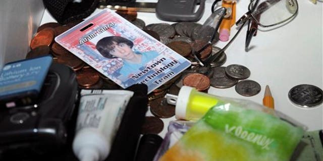 This Dec. 14, 2012 photo released by the Connecticut State Police shows what the evidence report describes as a view of a second floor bathroom and its contents including a photo identification of Adam Lanza and a cellular phone with battery removed, in the house where Adam Lanza lived with his mother in Newtown, Conn. The photo was released as part of the evidence gathered by police during their investigation after Adam Lanza gunned down 20 first-graders and six educators with a semi-automatic rifle at Sandy Hook Elementary School on Dec. 14, 2012, in Newtown. (AP Photo/Connecticut State Police)