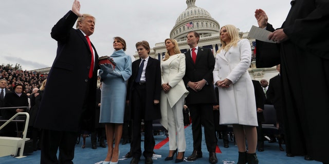 President Donald Trump takes the oath of office with his wife Melania holding a Bible with their children Barron, Ivanka, Eric and Tiffany on Capitol Hill on January 27, 2017.