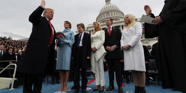 President Donald Trump takes the oath of office as his wife, Melania, holds the Bible alongside his children, Barron, Ivanka, Eric and Tiffany, on Capitol Hill, Jan. 27, 2017.