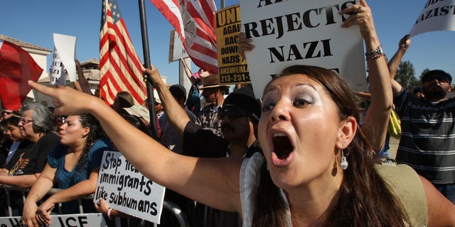 RIVERSIDE, CA - OCTOBER 24: Counter-protester Erika Paz yells at members of the white supremacist group, the National Socialist Movement, during the NSMÕs anti-illegal immigration rally near a Home Depot store on October 24, 2009 in Riverside, California. It is the second such demonstration in Riverside by the Detroit-based Neo-Nazi group in the past month. The last rally was soon broken up by police after clashes with counter-protesters. (Photo by David McNew/Getty Images)