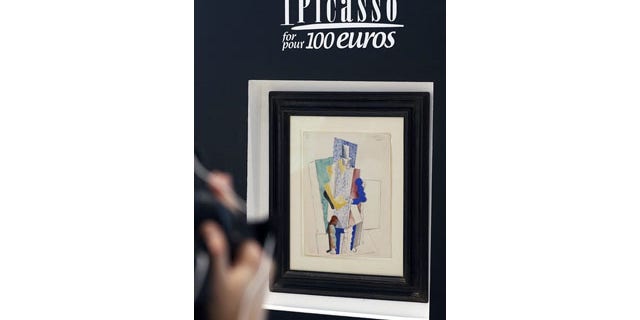December 12, 2013: Pablo Picasso's 1914 painting "Man with Opera Hat" on display in Paris (AP Photo)