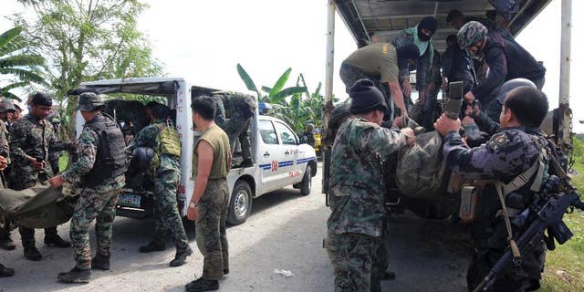 Members of the Philippine National Police Special Action Forces load bodies of police commandos into vehicles in Maguindanao, Philippines, Monday, Jan. 26, 2015. More than 40 Philippine police commandos were killed in a fierce battle with Muslim guerrillas after launching an assault in which they may have killed one of southeast Asia's most-wanted terrorists, officials said Monday. (AP Photo)