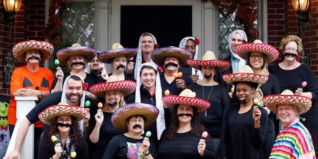 In this Oct. 28, 2015 photo, University of Louisville James Ramsey, lower right, and his wife, Jane, upper left, host a Halloween party in Louisville, Ky. The University of Louisville has apologized after the photo surfaced showing Ramsey among staffers dressed in stereotypical Mexican costumes. (Scott Utterback/The Courier-Journal via AP) NO SALES; MAGS OUT; NO ARCHIVE; MANDATORY CREDIT