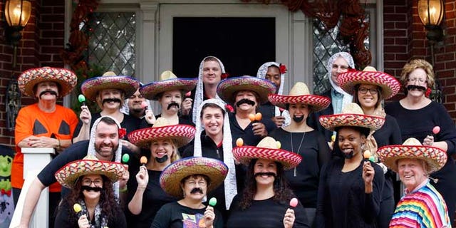 In this Oct. 28, 2015 photo, University of Louisville James Ramsey, lower right, and his wife, Jane, upper left, host a Halloween party in Louisville, Ky. The University of Louisville has apologized after the photo surfaced showing Ramsey among staffers dressed in stereotypical Mexican costumes. (Scott Utterback/The Courier-Journal via AP) NO SALES; MAGS OUT; NO ARCHIVE; MANDATORY CREDIT