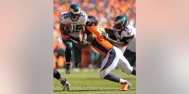 Philadelphia Eagles running back LeSean McCoy (25) takes a hit from Denver Broncos defensive end Robert Ayers (91) as Philadelphia Eagles tackle Jason Peters (71) tries to block in the first quarter of an NFL football game, Sunday, Sept. 29, 2013, in Denver. (AP Photo/Jack Dempsey)
