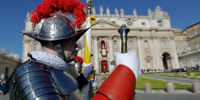 Vatican Swiss Guards stand at attention in front of St. Peter's Basilica prior to the arrival of Pope Francis to celebrate Easter Mass, Sunday, April 1, 2018.