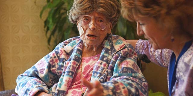 In this July 19, 2016, file photo, 113-year-old Adele Dunlap, left, talks with Susan Dempster, right, the activities director at the Country Arch Care Center in Pittstown, N.J.