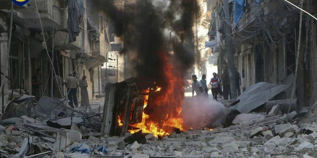 In this photo provided by the Syrian Civil Defense group known as the White Helmets, Syrians inspect damaged buildings after airstrikes by government helicopters on the rebel-held Aleppo neighborhood of Mashhad, Syria, Tuesday Sept. 27, 2016. With diplomacy in tatters and a month left to go before U.S. elections, the Syrian government and its Russian allies are using the time to try and recapture the northern city of Aleppo, mobilizing pro-government militias in the Old City and pressing ahead with the most destructive aerial campaign of the past five years. (Syrian Civil Defense White Helmets via AP)