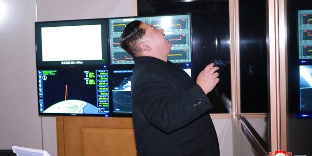 Kim Jong Un is pictured laughing while watching the missile launch.