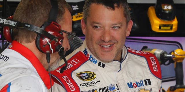 FILE - In this April 22, 2016, file photo, Tony Stewart, right, jokes with a crew member during practice for a NASCAR Sprint Cup auto race at Richmond International Raceway in Richmond, Va. Now that he's got his first victory in over three years, Stewart is able to realistically set some goals for his final season as a NASCAR driver. First up: Cross Kentucky Speedway off the list of active tracks where he's never won. (AP Photo/Steve Helber, File)