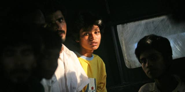 Newly arrived migrants sit inside a bus that will take them to a temporary shelter, in Simpang Tiga, Aceh province, Indonesia, Wednesday, May 20, 2015. In a major diplomatic breakthrough that could ease Southeast Asia's migrant crisis, Indonesia and Malaysia offered Wednesday to temporarily take in thousands of people who have been stranded at sea but appealed for international help, saying the crisis is a global, not regional, problem. (AP Photo/Binsar Bakkara)