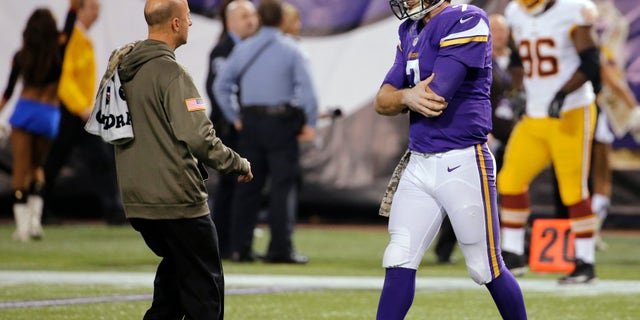 Minnesota Vikings quarterback Christian Ponder, right, is attended to by a trainer after an injury to his left shoulder during the second half of an NFL football game against the Washington Redskins, Thursday, Nov. 7, 2013, in Minneapolis. (AP Photo/Ann Heisenfelt)