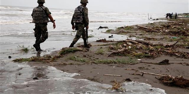 Sept. 10: Navy officers walk along El Bosque beach, in Mexico's Tabasco state. Mexico's state oil company and a Texas-based company searched for 10 missing oil workers on Friday, including four Americans, who evacuated from a research vessel in the Gulf of Mexico ahead of Tropical Storm Nate.