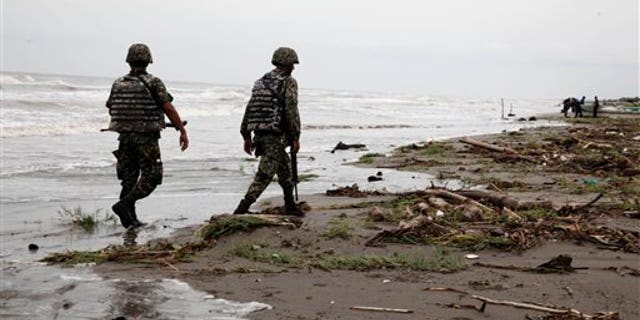 Sept. 10: Navy officers walk along El Bosque beach, in Mexico's Tabasco state. Mexico's state oil company and a Texas-based company searched for 10 missing oil workers on Friday, including four Americans, who evacuated from a research vessel in the Gulf of Mexico ahead of Tropical Storm Nate.