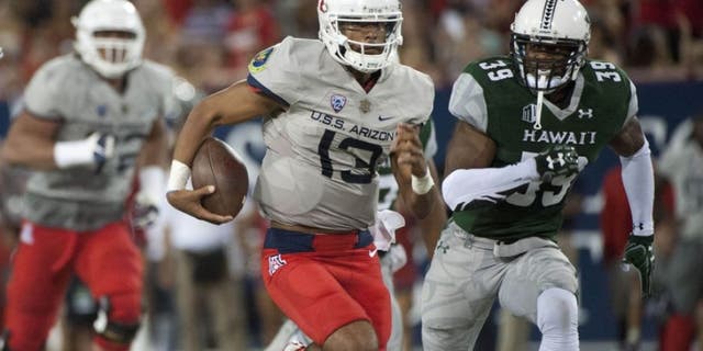 Sep 17, 2016; Tucson, AZ, USA; Arizona Wildcats quarterback Brandon Dawkins (13) runs the ball under pressure from Hawaii Warriors defensive back Trayvon Henderson (39) during the second quarter at Arizona Stadium. Mandatory Credit: Casey Sapio-USA TODAY Sports