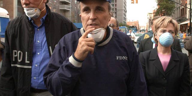 FILE - In this Wednesday, Sept. 12, 2001 file photo, New York City Mayor Rudolph Giuliani, center, leads New York Gov. George Pataki, left, and Sen. Hillary Clinton, D-N.Y., on a tour of the site of the World Trade Center disaster. While stumping for Donald Trump in Ocala, Fla., on Oct. 12, 2016, former New York City Mayor Rudy Giuliani accused Hillary Clinton of falsely claiming to have been in New York on Sept. 11, 2001. It isn’t clear what Giuliani was talking about. On many occasions, Clinton has described being in Washington, where Congress was in session, on Sept. 11 when hijacked jets began striking the World Trade Center and the Pentagon. Flights were still grounded on Sept. 12, 2001, but Clinton traveled to New York City the next day aboard a federal plane. There, she circled the smoldering World Trade Center in a helicopter, then toured ground zero with Giuliani and Pataki. (AP Photo/Robert F. Bukaty, File)