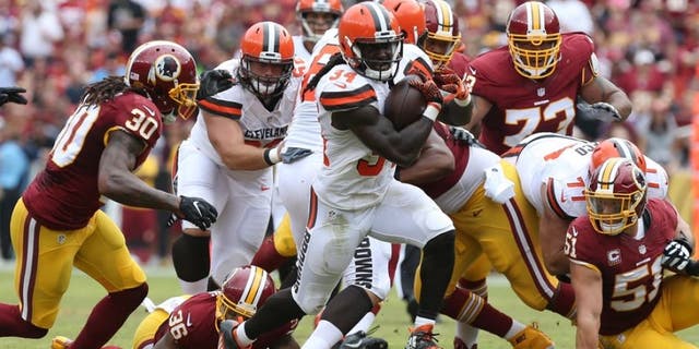 Oct 2, 2016; Landover, MD, USA; Cleveland Browns running back Isaiah Crowell (34) carries the ball past Washington Redskins safety David Bruton Jr. (30) and Redskins linebacker Will Compton (51) in the second quarter at FedEx Field. Mandatory Credit: Geoff Burke-USA TODAY Sports