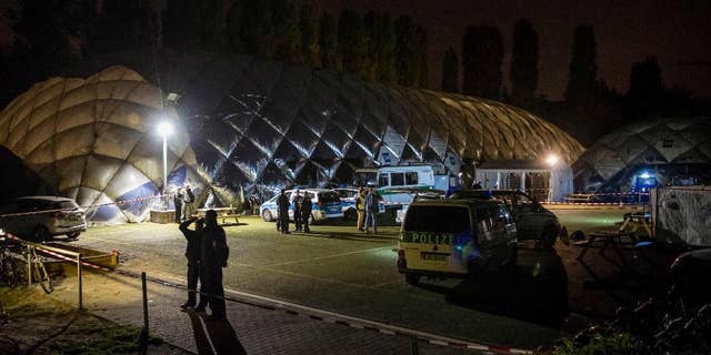 Police officers stand in front of an air-inflated structure which is a shelter for refugees in Berlin, Wednesday morning, Sept. 28, 2016. A 29-years-old man has been killed by police after a knife attack. (Gregor Fischer/dpa via AP)