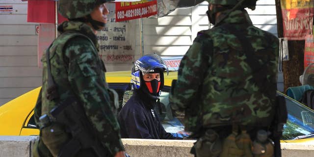 Thai soldiers guard on a street in Bangkok, Thailand, Thursday, May 22, 2014. Thailand's army chief Gen. Prayuth Chan-Ocha assumed the role of mediator Wednesday by summoning the country's key political rivals for face-to-face talks one day after imposing martial law. The meeting ended without any resolution, however, underscoring the profound challenge the army faces in trying to end the country's crisis. (AP Photo/Sakchai Lalit)