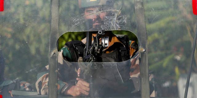 An Indian army soldier guards outside the base camp which was attacked by suspected militants at Baramulla, northwest of Srinagar, Indian controlled Kashmir, Monday, Oct. 3, 2016. A gun battle with a group of militants who attacked an Indian army camp in the Indian portion of Kashmir has ended early Monday morning, police said. (AP Photo/Mukhtar Khan)