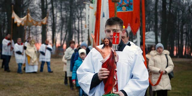 Devotees carry gonfalons during Easter Sunday rites in the village of Vselyub, 150 kilometers (93 miles) west of Minsk, Belarus, Sunday, March 27, 2016. (AP Photo/Sergei Grits)