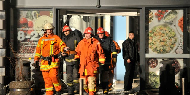 Rescuers work at the Maxima grocery store after its roof collapsed in Riga, Latvia, Thursday, Nov. 21, 2013. Latvian rescue officials say a roof at a large grocery store in the country's capital collapsed and killed several people and injuring more than a dozen people. (AP Photo/Roman Koksarov)