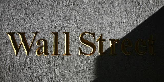 FILE - In this Monday, March 8, 2010, file photo, a sign for Wall Street is shown near the New York Stock Exchange. Global shares were mixed Wednesday Aug. 27, 2014 after the latest record close for the Standard &amp; Poor's 500, with Europe off to a shaky start despite a strong day in Asia. (AP Photo/Mark Lennihan, File)
