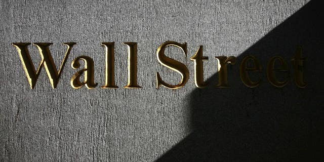FILE - In this Monday, March 8, 2010, file photo, a sign for Wall Street is shown near the New York Stock Exchange. Global shares were mixed Wednesday Aug. 27, 2014 after the latest record close for the Standard & Poor's 500, with Europe off to a shaky start despite a strong day in Asia. (AP Photo/Mark Lennihan, File)
