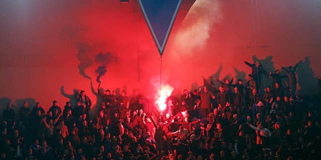 PSG fans light flares during the Champions League round of 16 first leg soccer match between Paris Saint Germain and Chelsea at the Parc des Princes stadium in Paris, France, Tuesday, Feb. 17, 2015. (AP Photo/Christophe Ena)
