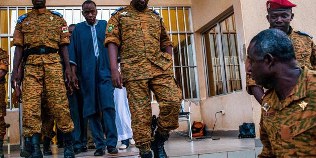 Burkina Faso Lt. Col. Issac Yacouba Zida, center, leaves a government building after meeting with political leaders in Ouagadougou, Burkina Faso, Tuesday, Nov. 4, 2014. International envoys tried Tuesday to resolve Burkina Faso's political crisis, with the specter of a power vacuum looming after the country's longtime president fled last week. (AP Photo/Theo Renaut)