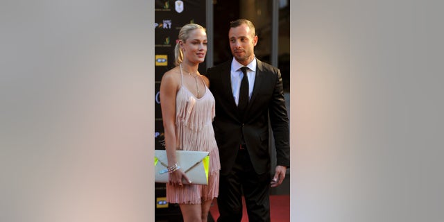 In this Nov. 4, 2012 photo, South African Olympic athlete Oscar Pistorius and Reeva Steenkamp, believed to be his girlfriend, at an awards ceremony, in Johannesburg, South Africa. Olympic athlete Oscar Pistorius was taken into custody and was expected to appear in court Thursday, Feb. 14, 2013, after a 30-year-old woman who was believed to be his girlfriend was shot dead at his home in South Africa's capital, Pretoria. (AP Photo/Lucky Nxumalo-Citypress) SOUTH AFRICA OUT