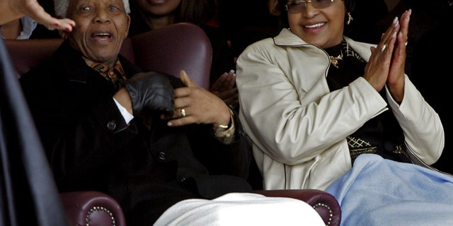 FILE - In this Thursday, Aug. 21, 2008 file photo former president Nelson Mandela, left, and his ex-wife Winnie Madikizela-Mandela, right, during the unveiling of a statue of Mandela at the Drakenstein Prison near Franschhoek, South Africa. Madikizela-Mandela told a South African newspaper published Sunday Nov. 17, 2013, that Mandela, remains "quite ill" and unable to speak because of tubes that are keeping his lungs clear of fluid, though he is relaxed. (AP Photo/Schalk van Zuydam-File)