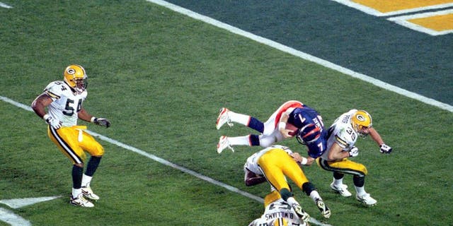 Denver quarterback John Elway goes airborne to pick up a first down in Super Bowl XXXII at Qualcomm Stadium in San Diego, CA. The Broncos defeated the Green Bay Packers 31-24 on 1/25/1998. (Photo by Kevin Reece/Getty Images)