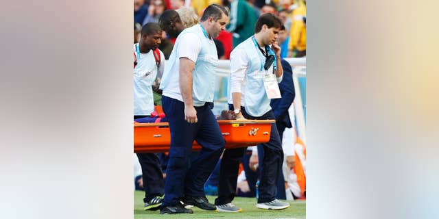 Netherlands' Bruno Martins Indi is carried off the pitch in a stretcher after a collision with Australia's Tim Cahill during the group B World Cup soccer match between Australia and the Netherlands at the Estadio Beira-Rio in Porto Alegre, Brazil, Wednesday, June 18, 2014. (AP Photo/Jon Super)