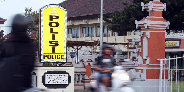 Motorcyclists pass by Denpasar's police station where Rajendra Sadashiv Nikalje is detained, in Bali, Indonesia, Monday, Oct. 26, 2015. Nikalje, known in India as “Chotta Rajan,” an alleged mafia boss in his homeland was on the Interpol’s most wanted list for two decades, said Bali police spokesman Heri Wiyanto. Wiyanto said Nikalje was arrested Sunday after arriving at Bali’s airport from Sydney, based on a red notice from Interpol and following a tip from Australian authorities in Canberra. (AP Photo/Firdia Lisnawati)