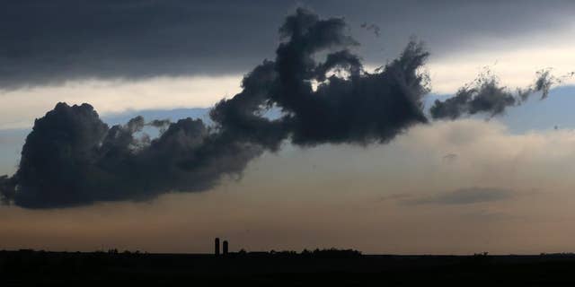 A low cloud moves over a farm near Gypsum, Kan., Tuesday, April 26, 2016. Thunderstorms bearing hail as big as grapefruit and winds approaching hurricane strength lashed portions of the Great Plains on Tuesday. The area is expecting severe weather. (AP Photo/Orlin Wagner)