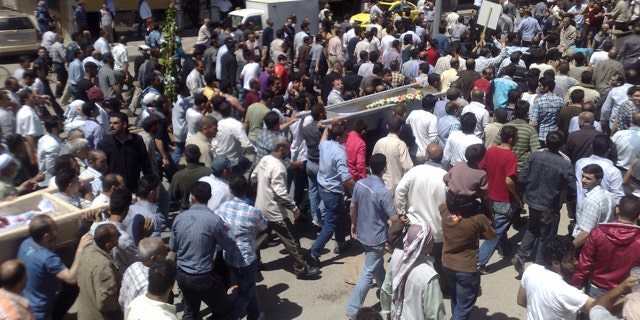 May 21: In this citizen journalism image made on a mobile phone and acquired by the AP, Syrian anti-government supporters carry the coffins of people whom they say were killed in the government crackdown, in the central city of Homs, Syria.