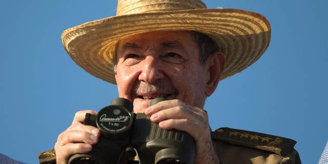 Cuba's President Raul Castro uses binoculars to watch the May Day march at Revolution Square in Havana, Cuba, Monday, May 1, 2017. (AP Photo/Desmond Boylan)