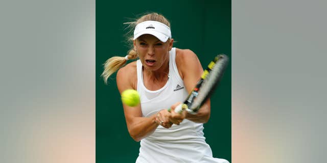 Caroline Wozniacki of Denmark plays a return to Shahar Peer of Israel during their first round match at the All England Lawn Tennis Championships in Wimbledon, London, Monday, June 23, 2014. (AP Photo/Alastair Grant)