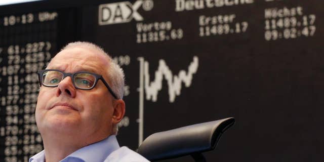 A trader watches his screens at the stock market in Frankfurt, Germany, Monday, July 13, 2015. Global stock markets bounced higher Monday after Greece and its European creditors agreed on a bailout deal, substantially reducing the uncertainty about Greece's future in the euro common currency. (AP Photo/Michael Probst)