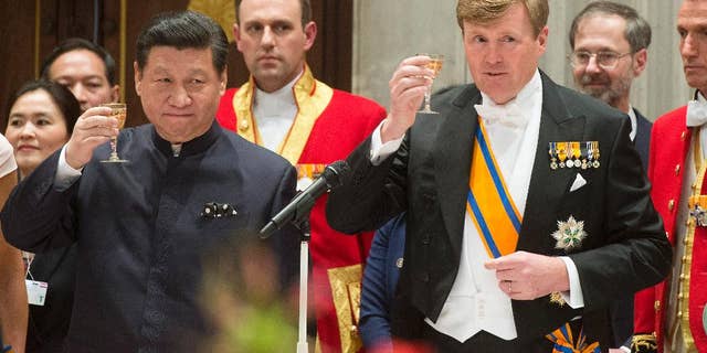 China's President Xi Jinping, left, and Dutch King Willem Alexander, right, propose a toast during the official state banquet at the royal palace in Amsterdam, Netherlands, Saturday March 22, 2014. Xi is on a two-day state visit ahead of the March 24 and 25 Nuclear Security Summit in The Hague. (AP Photo/Toussaint Kluiters, Pool)