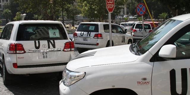 FILE -- In this August 26, 2013, file Photo, a U.N. team, that is scheduled to investigate an alleged chemical attack that killed hundreds last week in a Damascus suburb, leaves their hotel in a convoy, in Damascus, Syria. In a statement issued Tuesday, May 27, 2014, by the chemical weapons watchdog that is overseeing the dismantling of Syria's chemical weapons program, said a convoy of its inspectors has come under attack, but all are safe. The Organization for the Prohibition of Chemical Weapons said that the inspectors had been traveling to the site of an alleged chlorine gas attack site when they were attacked. (AP Photo, File)