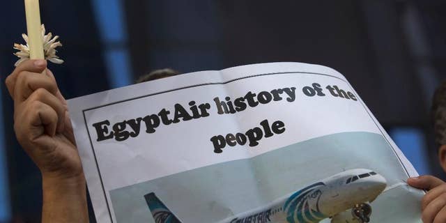 FILE - In this May 24, 2016 file photo, an Egyptian journalist holds a candle and a poster supporting EgyptAir during a candlelight vigil for the victims of EgyptAir flight 804 in front of the Journalists' Syndicate in Cairo, Egypt. Egypt on Wednesday, June 15, 2016, said that it spotted and obtained images from the wreckage of the EgyptAir plane flying from Paris to Cairo that crashed into the Mediterranean last month, killing all 66 people on board, according to a statement by the country's investigation committee. (AP Photo/Amr Nabil, File)