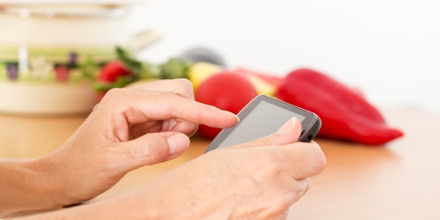 Woman reading a recipe on her smart phon.