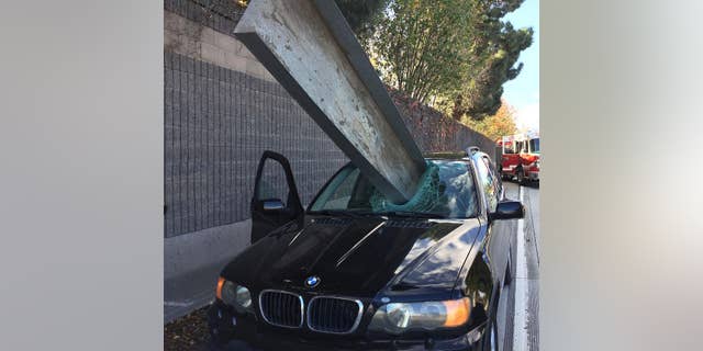 This Friday, Dec. 11, 2015 photo provided by the San Jose Fire Department shows a beam that fell off of a flatbed truck that impaled the window of a BMW car on I-280 in San Jose, Calif. The driver of the BMW, Don Lee, suffered only a small scratch to his right arm. (Courtesy San Jose Fire Department via AP) MANDATORY CREDIT