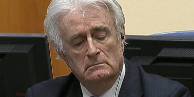 In this image taken from video Bosnian Serb wartime leader Radovan Karadzic listens to the his sentence at the International Criminal Tribunal for Former Yugoslavia (ICTY) in The Hague, The Netherlands Thursday March 24, 2016. Karadzic was convicted of genocide and nine other charges Thursday at a U.N. court, and sentenced to 40 years in prison. (ICTY, Pool via AP)