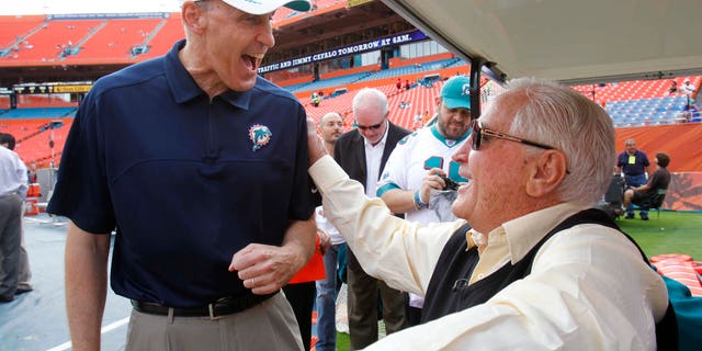 In this Sunday, Dec. 16, 2012, photo, Miami Dolphins coach Joe Philbin, left, and former coach Don Shula speak before an NFL football game, Sunday, Dec. 16, 2012, in Miami. Shula is optimistic Philbin and rookie Ryan Tannehill will put an end to years of steady turnover at the head coach and quarterback positions. (AP Photo/Wilfredo Lee)