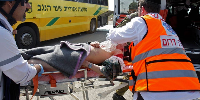 April 7: A wounded Israeli is treated by medics at the site where an Israeli school bus was hit by a mortar shell fired from the Gaza Strip near the border between southern Israel and Gaza Wednesday. A Palestinian mortar shell from the Gaza Strip struck a school bus in southern Israel Thursday, wounding two people, including one child critically, Israeli officials said.